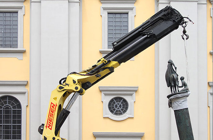 Kran hebt Skulptur